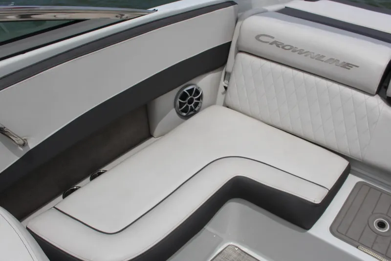 Slide: The Image of 2022 Crownline 240 SS boat interior with white cushioned seating and speaker. - 7
