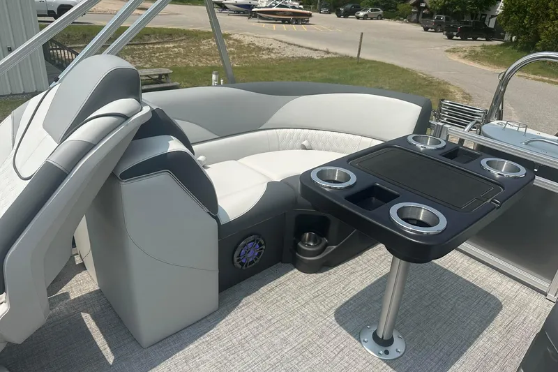 Slide: The Image of 2025 Tahoe 2185 boat interior with plush seating and a table featuring cup holders. - 15