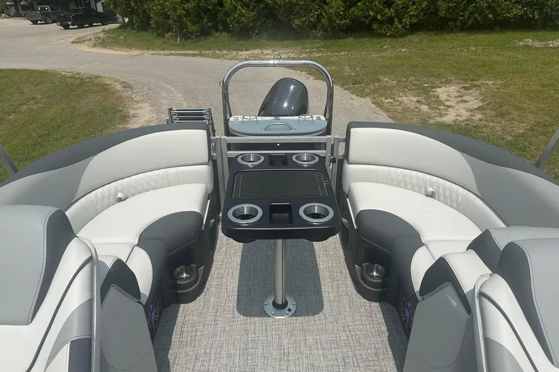 Slide: The Image of 2025 Tahoe 2185 boat interior with plush seating and cup holders, parked on a grassy area. - 17