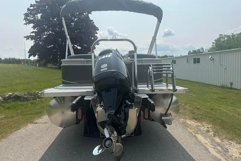 Slide: The Image of 2025 Tahoe 2185 pontoon boat with outboard motor on a sunny day. - 4