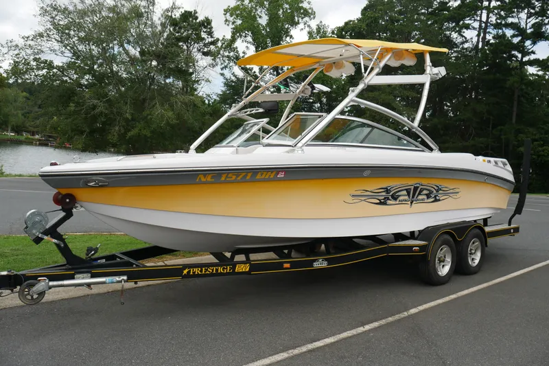The Image of 2007 Correct Craft 236 Team Edition boat on trailer, parked near a lake. - 1