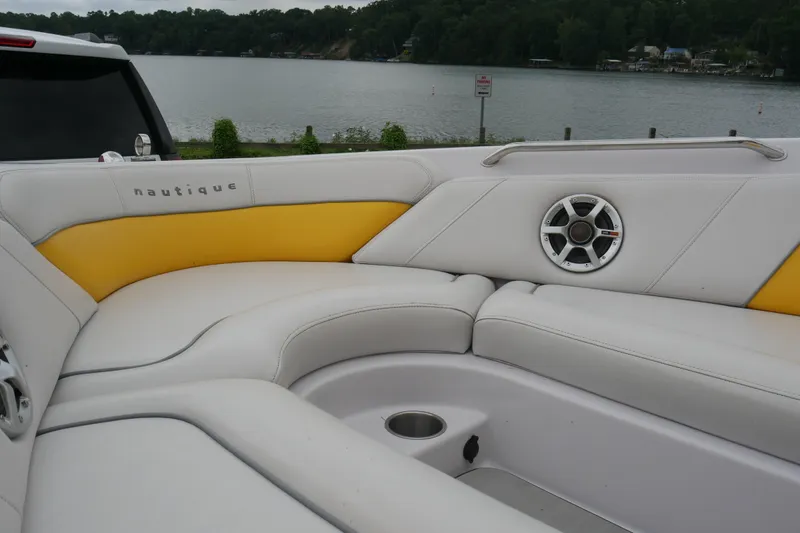 Slide: The Image of 2007 Correct Craft 236 Team Edition boat interior with yellow accents and speaker, lakeside view. - 12