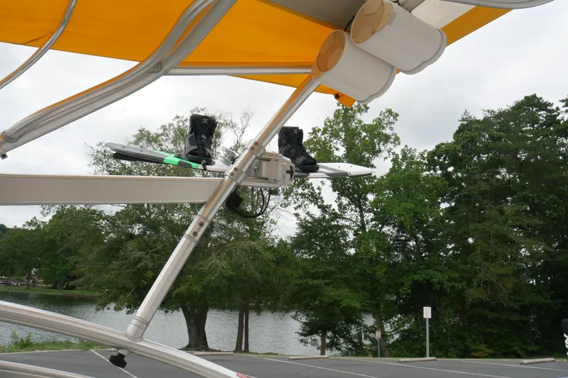 Slide: The Image of 2007 Correct Craft 236 Team Edition boat with wakeboard rack and speakers, near a lake. - 15