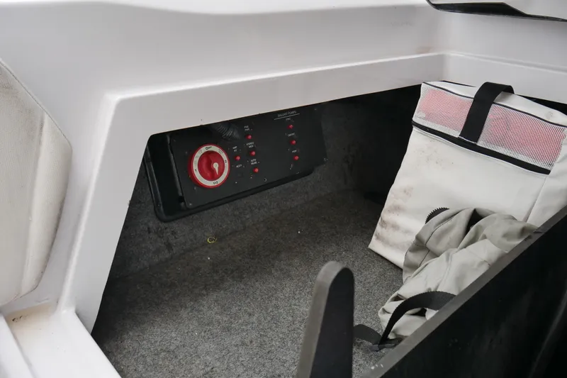 Slide: The Image of 2007 Correct Craft 236 Team Edition storage compartment with control panel and gear. - 18