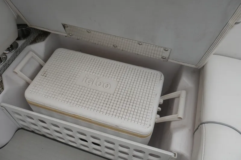 Slide: The Image of White Igloo cooler stored in a 2007 Correct Craft 236 Team Edition boat compartment. - 20