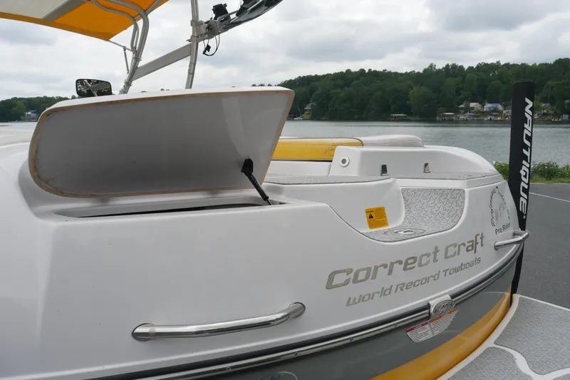 Slide: The Image of 2007 Correct Craft 236 Team Edition boat with open storage, docked by a scenic lake. - 28