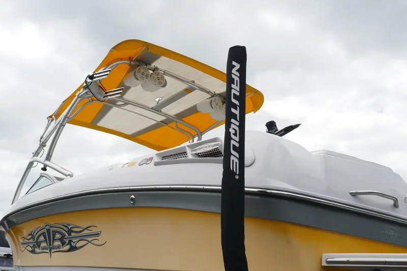 Slide: The Image of 2007 Correct Craft 236 Team Edition boat with yellow canopy and Nautique branding. - 34