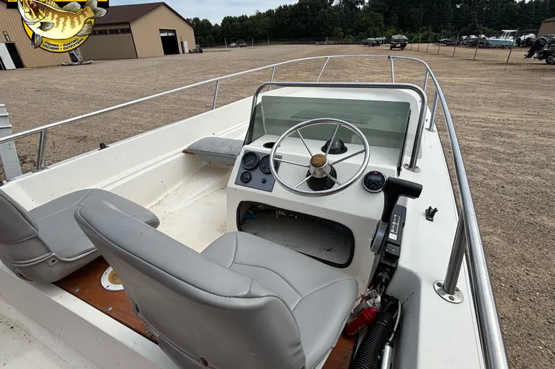 Slide: The Image of 1986 Wahoo 16.2 boat interior with steering wheel and gray seats. - 10