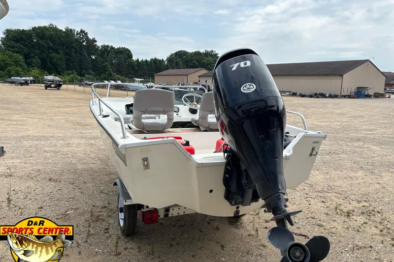 Slide: The Image of 1986 Wahoo 16.2 boat with 70 HP outboard motor in a parking lot. - 5