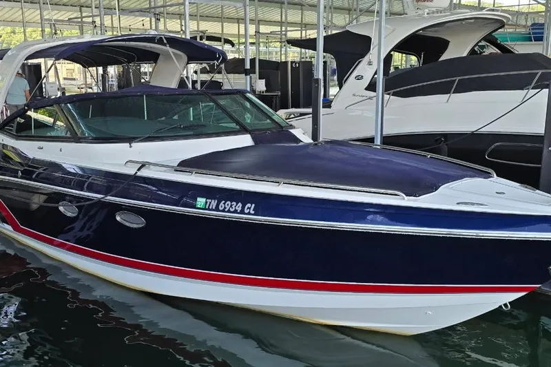 Slide: The Image of 2016 Formula 330 Crossover Bowrider on trailer by a lake, sunny day. - 1