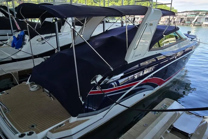 Slide: The Image of 2016 Formula 330 Crossover Bowrider on trailer by a lake under clear sky. - 2