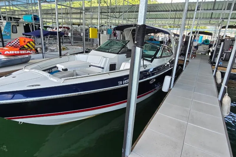 Slide: The Image of 2016 Formula 330 Crossover Bowrider boat parked near modern glass building. - 3