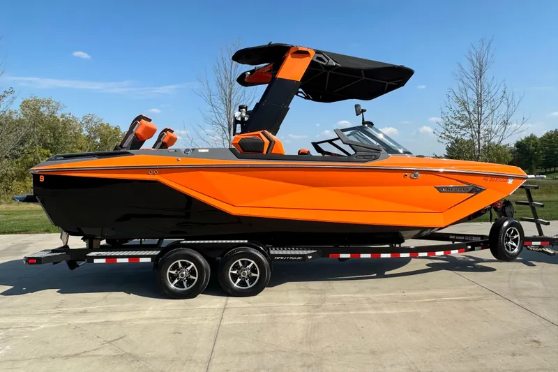 Slide: The Image of 2022 Nautique Super Air Nautique G25 Paragon boat in vibrant orange on trailer. - 1