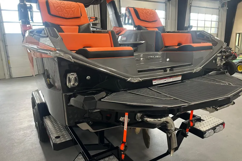 Slide: The Image of 2022 Nautique Super Air Nautique G25 Paragon with orange seating in a showroom. - 6