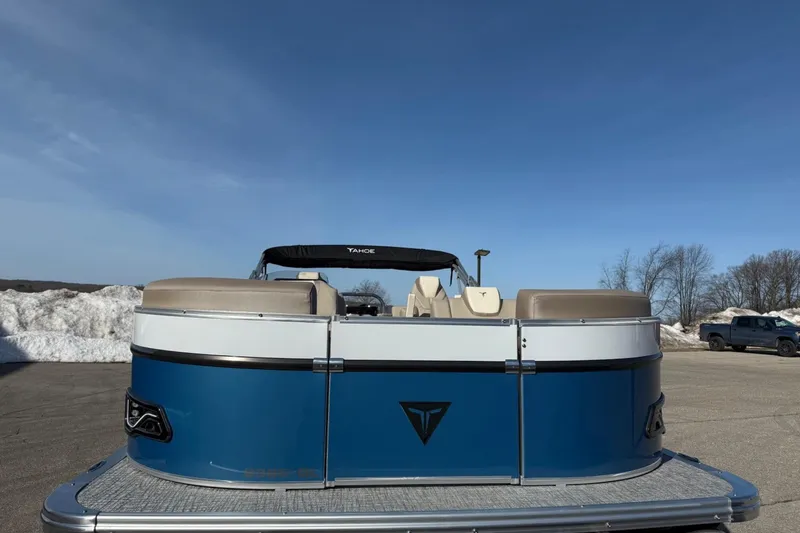 Slide: The Image of 2025 Tahoe 2385 pontoon boat with blue exterior, parked on a snowy lot under clear skies. - 10