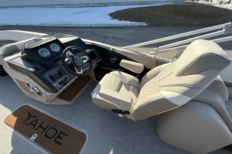 Slide: The Image of 2025 Tahoe 2385 boat cockpit with beige captain's chair and modern dashboard controls. - 15