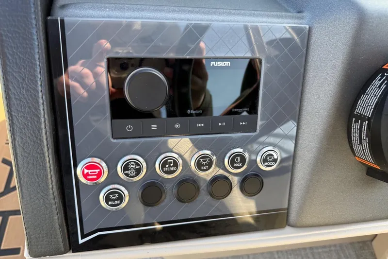 Slide: The Image of Control panel of 2025 Tahoe 2385 boat with Fusion audio system and various function buttons. - 17