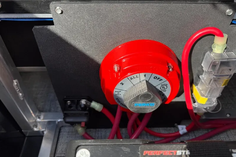 Slide: The Image of Red battery switch in a 2025 Tahoe 2385 boat, featuring Perko brand and wiring connections. - 24