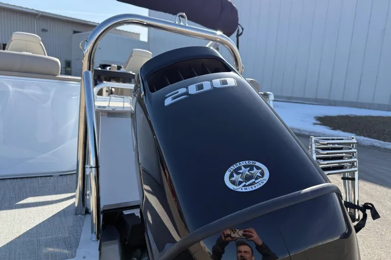 Slide: The Image of 2025 Tahoe 2385 boat with 200 HP ultra-low emission engine, docked outdoors. - 6