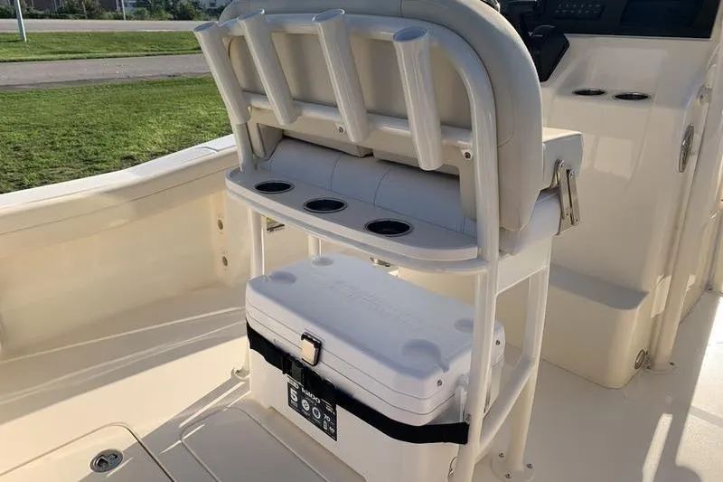 Slide: The Image of 2026 Scout 215 XSF boat interior with rod holders and cooler storage. - 13