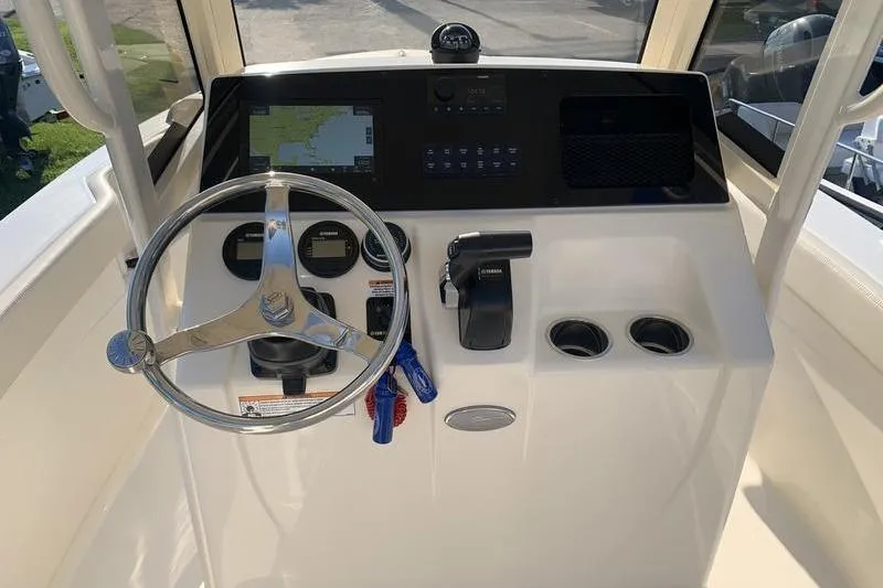 Slide: The Image of 2026 Scout 215 XSF boat dashboard with steering wheel, controls, and navigation display. - 20