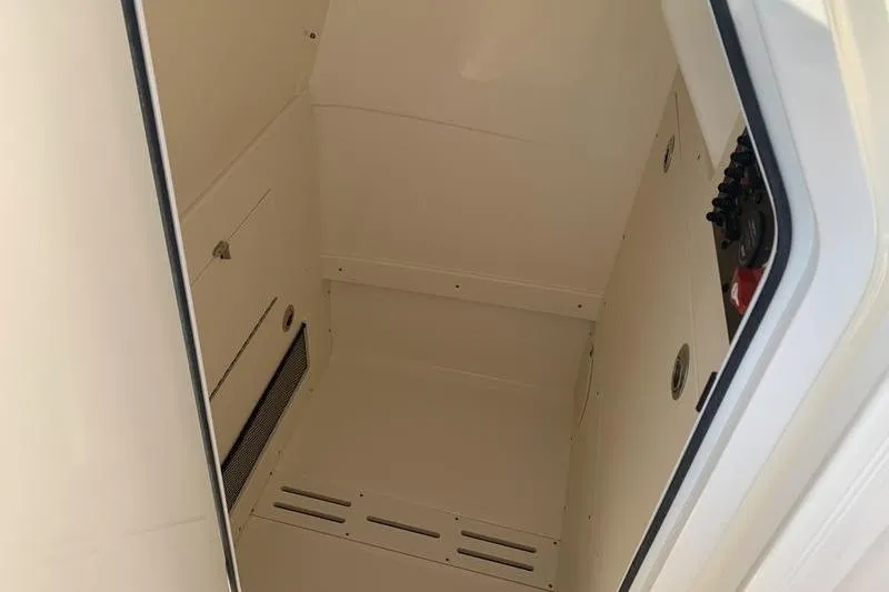 Slide: The Image of 2026 Scout 215 XSF boat interior storage compartment, featuring a clean, white design. - 26