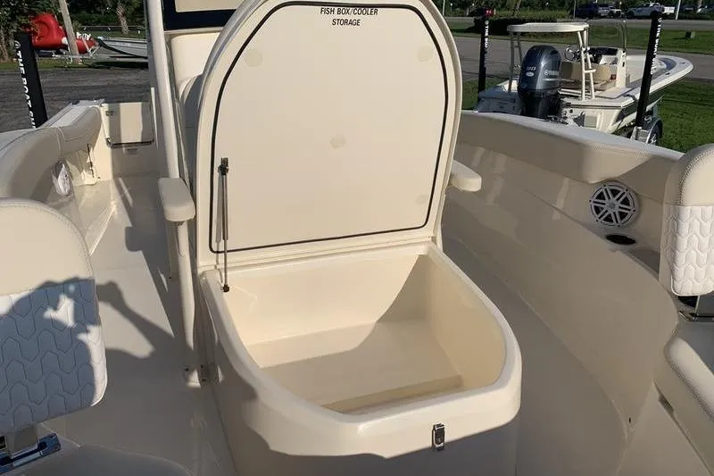 Slide: The Image of 2026 Scout 215 XSF boat with open fish box cooler storage. - 30