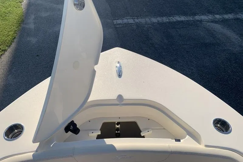 Slide: The Image of 2026 Scout 215 XSF boat bow with open storage compartment and cup holders. - 32