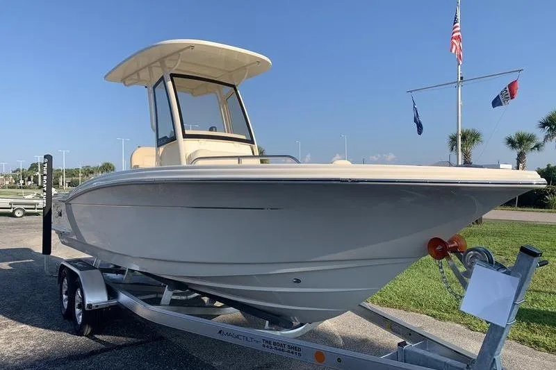 Slide: The Image of 2026 Scout 215 XSF boat on trailer, parked outdoors under clear sky. - 6