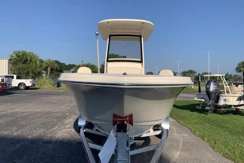 Slide: The Image of 2026 Scout 215 XSF boat on trailer, parked outdoors under clear blue sky. - 7