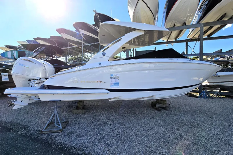 Slide: The Image of 2026 Regal LX9 boat displayed on a stand, surrounded by other boats. - 1