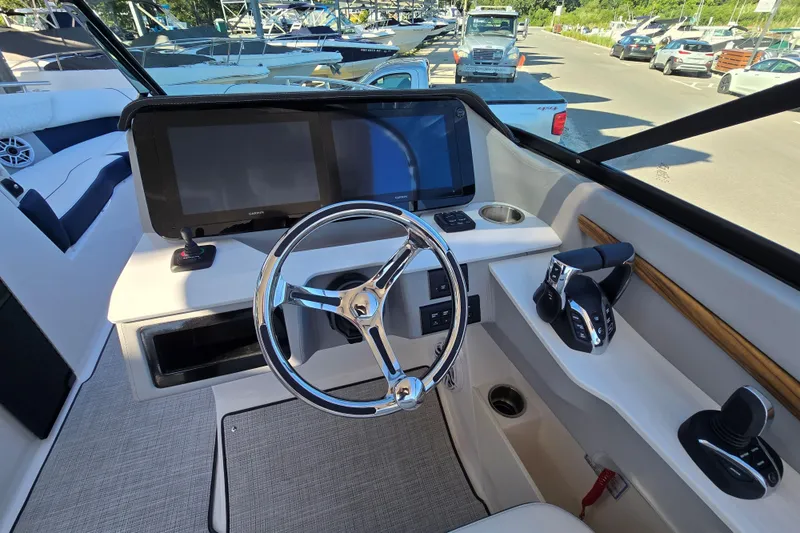 Slide: The Image of 2026 Regal LX9 boat helm with modern controls and dual screens at marina. - 5