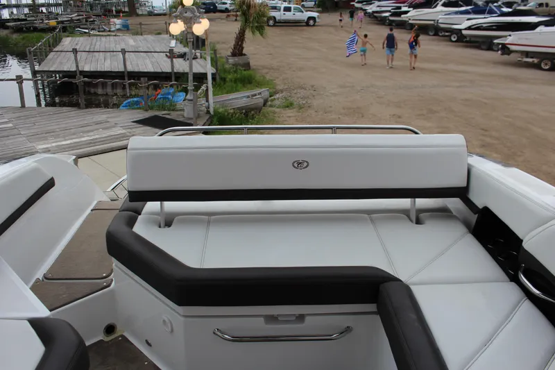 Slide: The Image of 2021 Cobalt R6 Surf boat interior with white seating at a marina. - 6
