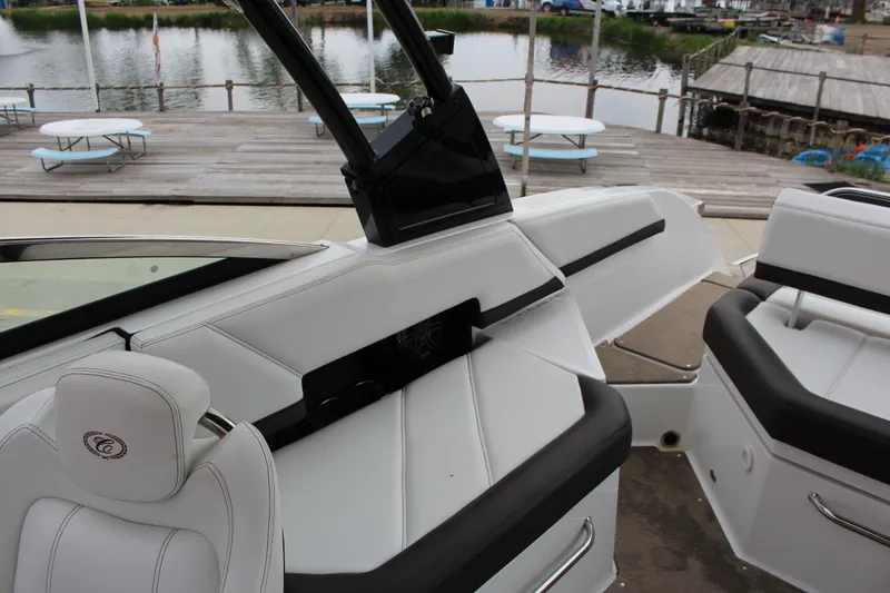 Slide: The Image of 2021 Cobalt R6 Surf boat interior with white and black seating by a dockside. - 7