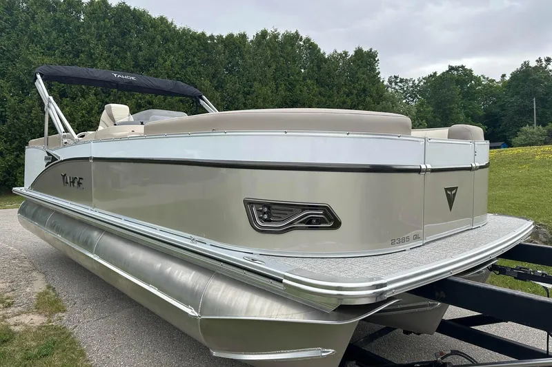 Slide: The Image of 2025 Tahoe 2385 pontoon boat on trailer, sleek design, parked outdoors. - 11