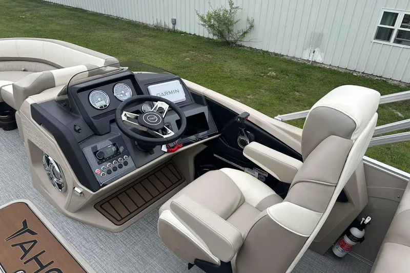Slide: The Image of 2025 Tahoe 2385 boat cockpit with steering wheel, Garmin display, and comfortable seating. - 21