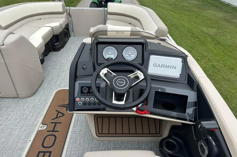 Slide: The Image of 2025 Tahoe 2385 boat interior with steering wheel, Garmin display, and seating. - 29