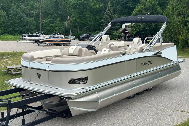 Slide: The Image of 2025 Tahoe 2385 pontoon boat with sleek design, parked outdoors. - 3