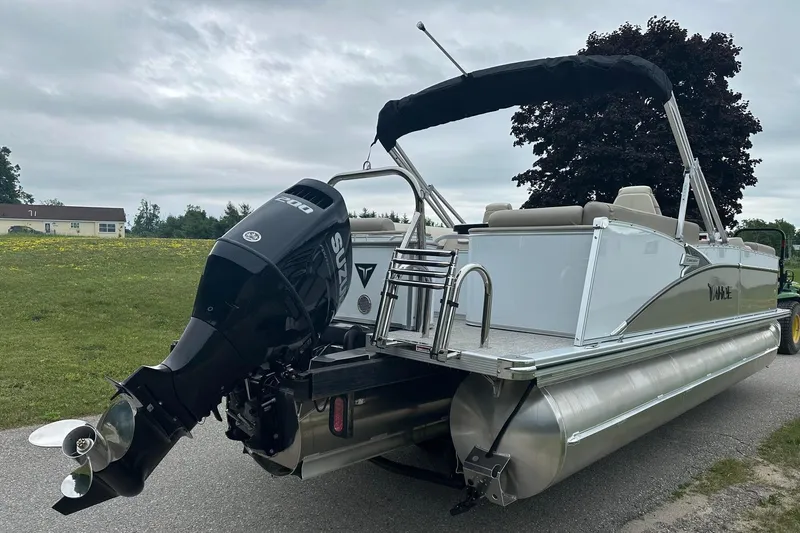 Slide: The Image of 2025 Tahoe 2385 pontoon boat with Suzuki 200 outboard motor on a grassy area. - 8