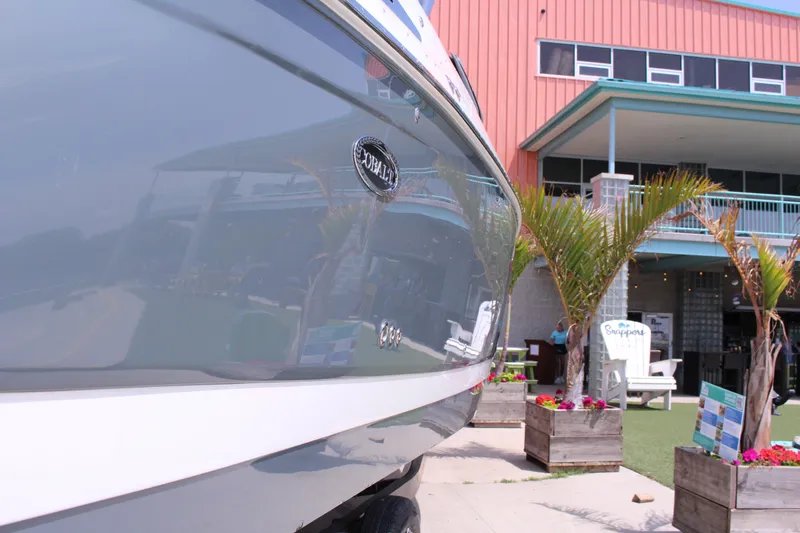 The Image of 2021 Cobalt R35 Surf boat docked near a modern building with palm trees. - 0