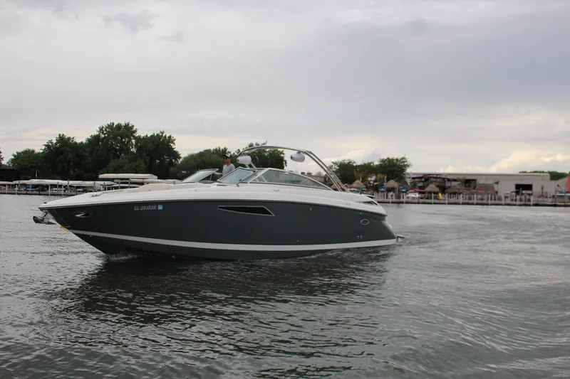 Slide: The Image of 2021 Cobalt R35 Surf boat cruising on a calm lake under a cloudy sky. - 11