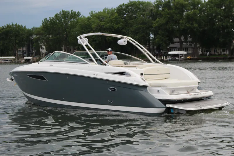 Slide: The Image of 2021 Cobalt R35 Surf boat cruising on a lake with lush green trees in the background. - 13