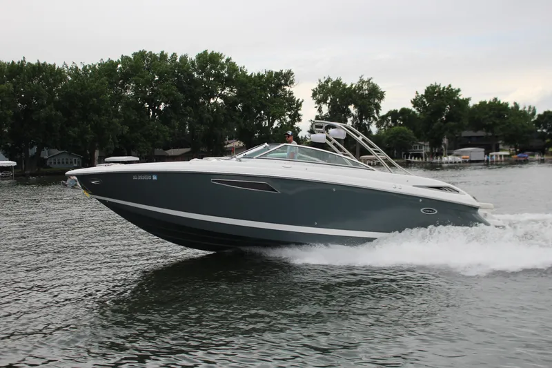 Slide: The Image of 2021 Cobalt R35 Surf boat cruising on a lake with trees in the background. - 15