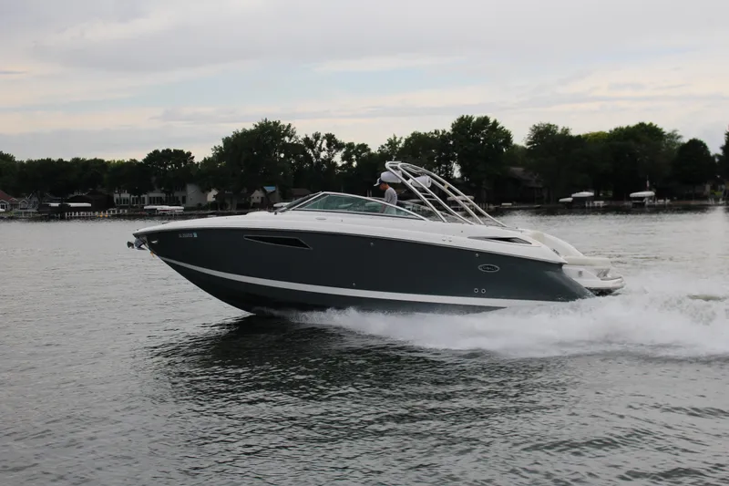 Slide: The Image of 2021 Cobalt R35 Surf boat cruising on a calm lake with trees in the background. - 18