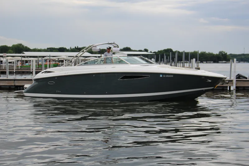 Slide: The Image of 2021 Cobalt R35 Surf boat docked on calm water under cloudy sky. - 2