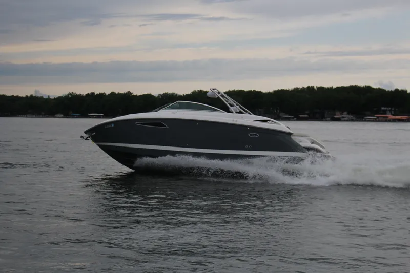 Slide: The Image of 2021 Cobalt R35 Surf boat cruising on a lake under a cloudy sky. - 21
