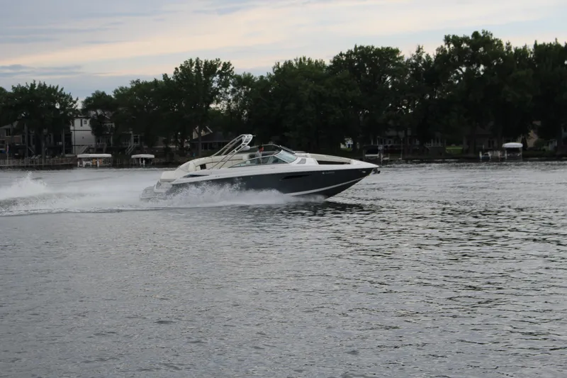 Slide: The Image of 2021 Cobalt R35 Surf boat speeding on a lake with trees in the background. - 24