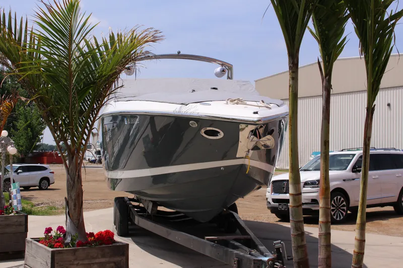 Slide: The Image of 2021 Cobalt R35 Surf boat on trailer, surrounded by palm trees and parked cars. - 26