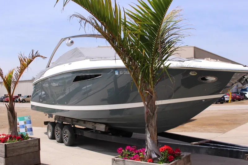 Slide: The Image of 2021 Cobalt R35 Surf boat on trailer, surrounded by palm trees and flowers. - 27