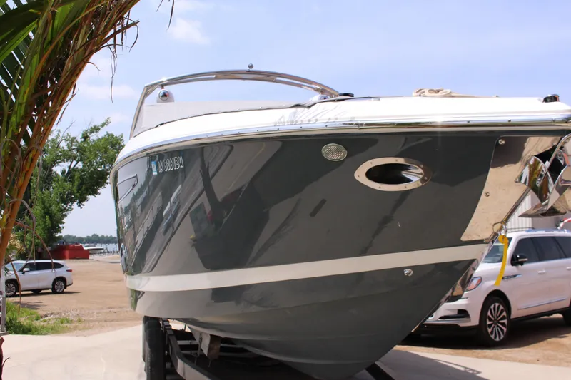 Slide: The Image of 2021 Cobalt R35 Surf boat on trailer, parked outdoors near vehicles. - 28